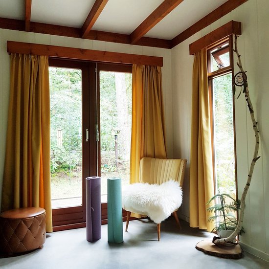 Twee opgerolde yogamatten, paars en mintgroen, in een woonkamer.