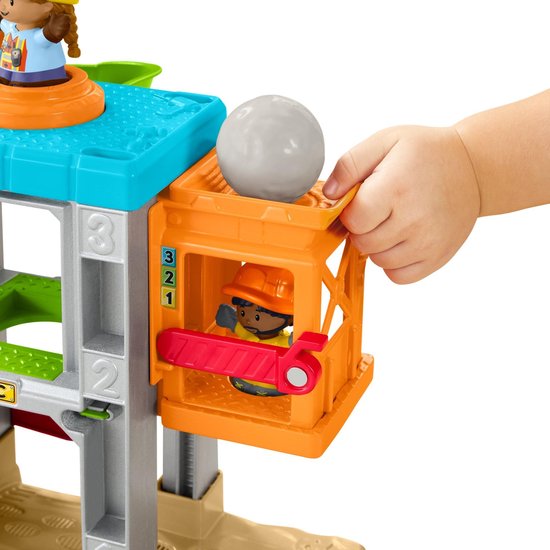 Hand bedient de lift op de Little People bouwplaats-speelset met een rots.