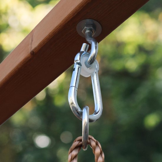 Detail van metalen karabijnhaak en touwschommel bevestiging aan houten speeltoren.