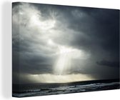 Canvas Schilderij Zonlicht dat door onweerswolken heen gaat - 60x40 cm - Wanddecoratie