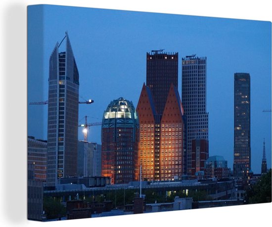 Canvas Schilderij Den Haag - Wolkenkrabber - Nacht - 60x40 cm - Wanddecoratie