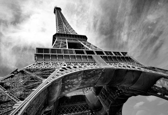 Photo noir et blanc de la Tour Eiffel vue d'en bas, avec un ciel dramatique.