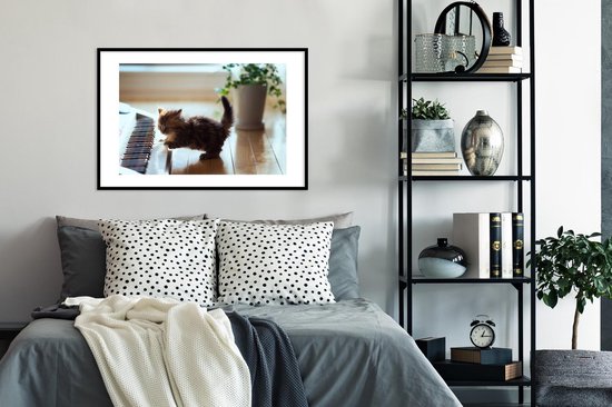 Chaton jouant avec un cadre photo piano noir avec passe-partout blanc 60x90