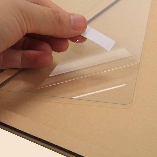 Hand trekt beschermfolie van een glazen screenprotector.