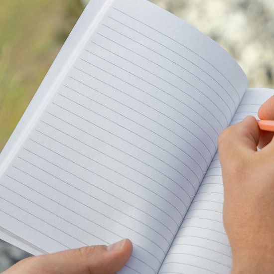Open mosgroen Sigel Re-Up notitieboek, gelinieerd, papier van katoenafval en theebladeren. Hand schrijft met oranje potlood.