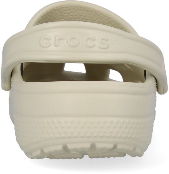Crème Crocs klomp met klittenband en "Crocs" logo op de band.