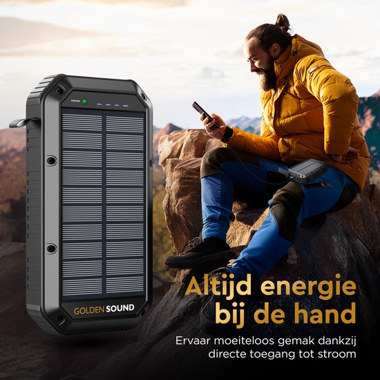 Man met gele jas zittend op rots, gebruikt zwarte powerbank met zonnepaneel. "Altijd energie bij de hand" tekst.