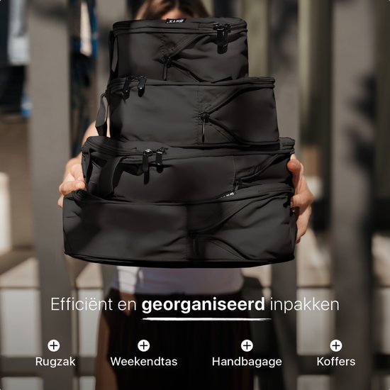 Een persoon houdt vier zwarte ONYX compressie packing cubes van verschillende groottes voor een koffer.