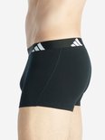 Zij-aanzicht van zwarte boxer met brede zwarte tailleband met witte Adidas-strepen.