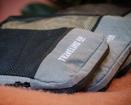 Grijze packing cube met mesh en "Traveling Kid" logo op een oranje achtergrond.