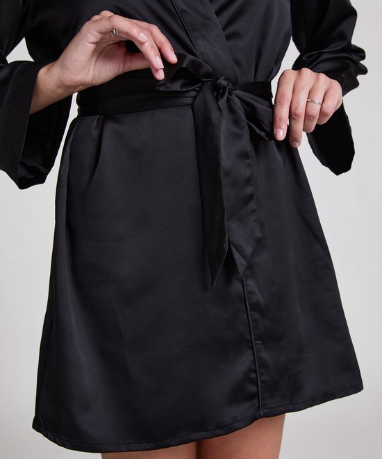 Close-up van de taille van een model die een zwarte satijnen kimono strikt.