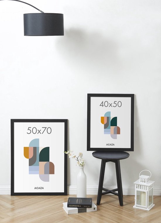 Twee zwarte fotolijsten, 50x70 cm en 40x50 cm, met abstracte geometrische prints in pastelkleuren, staand op een houten vloer.