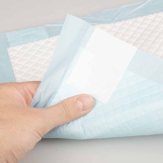 Een hand houdt een deel van een absorberend kussen omhoog. Het is blauw met een wit ruitpatroon.