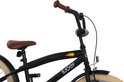 Close-up van het stuur en zadel van een zwarte kinderfiets met bruine accenten.