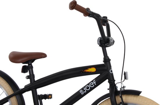 Close-up van het stuur en zadel van een zwarte kinderfiets met bruine accenten.