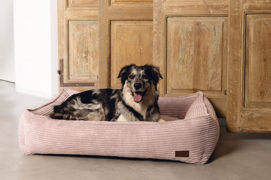 Roze corduroy hondenmand met een hond met roze en zwarte vlekken.