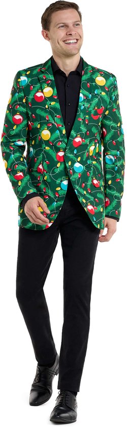 Groen colbert met een opdruk van kerstlampjes, kerstballen en dennentakken. Een man draagt het colbert met een zwarte blouse en broek.