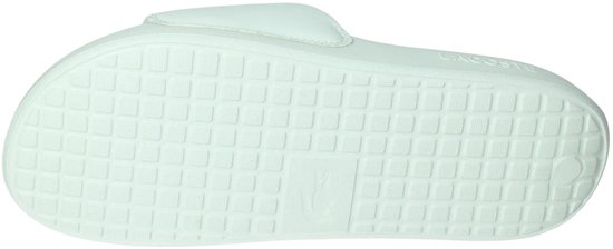 Zolen van witte Lacoste badslippers met gegroefd patroon en krokodil logo.