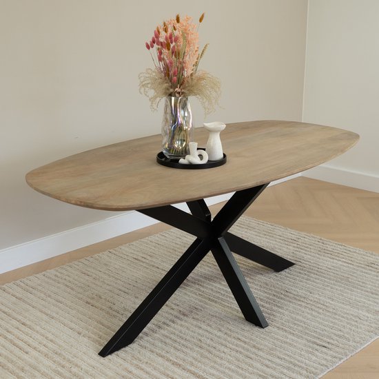 Table à manger avec un vase de fleurs séchées et des décorations.