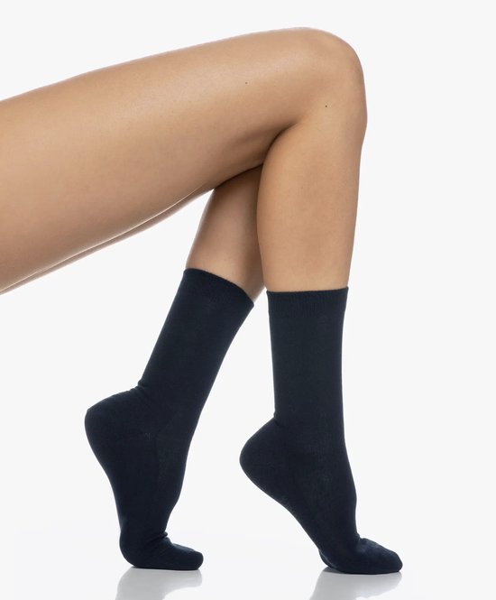 Een model draagt twee donkerblauwe, effen sokken.