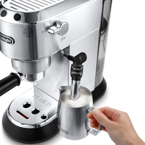 Hand die melk opschuimt met de cappuccinosysteem van een zilverkleurig De'Longhi espressoapparaat.