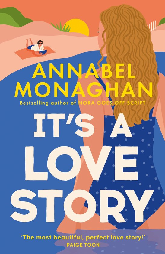 Boekcover met de titel 'It's a Love Story' van Annabel Monaghan. Een vrouw in badpak kijkt weg van de camera, met een zwembad en een zonnig strandlandschap op de achtergrond.
