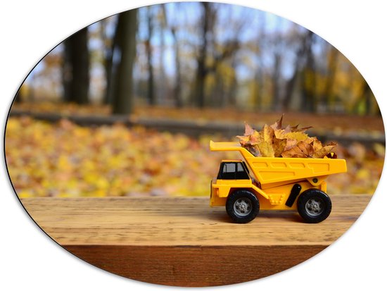 Dibond Ovaal - Gele Mini Kiepwagen Gevuld met Herfstbladeren in het Bos - 80x60 cm Foto op Ovaal (Met Ophangsysteem)