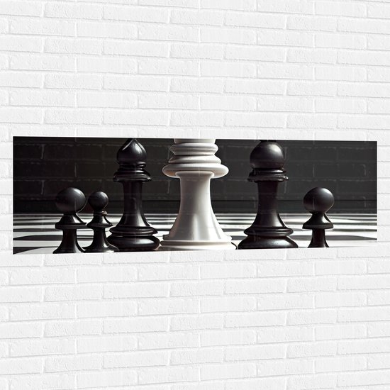 Muursticker - Zwarte Schaakstukken om Witte Koning op Schaakbord (Zwart-wit) - 150x50 cm Foto op Muursticker