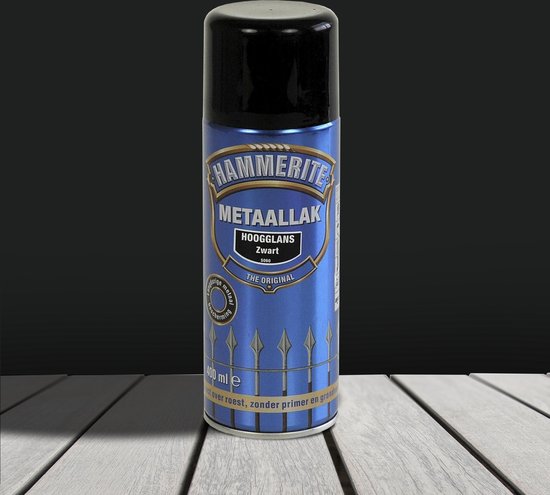 Hammerite Metaallak Hoogglans Zwart spuitbus met blauw label, afbeelding van een hek, op houten ondergrond.