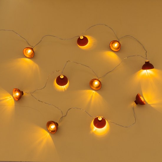 Een lichtsnoer met 10 terracottakleurige lampjes met kapjes, op een lichtgeel oppervlak.