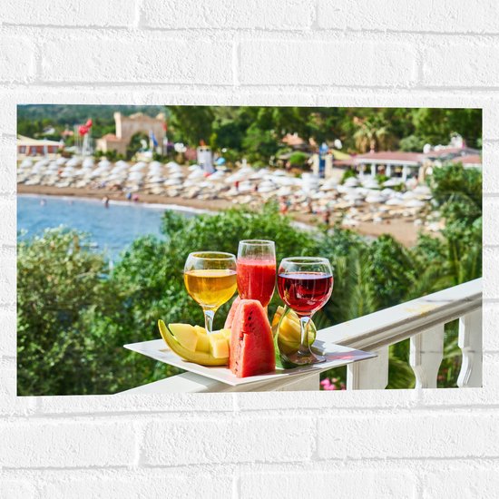 Muursticker - Gekleurde Drankjes met Stukken Fruit en Uitzicht op een Baai - 60x40 cm Foto op Muursticker