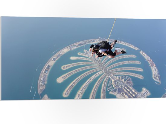 PVC Schuimplaat- Parachutespringer boven de Palm van Dubai - 100x50 cm Foto op PVC Schuimplaat