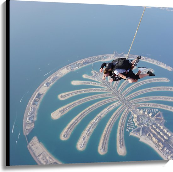Canvas - Parachutespringer boven de Palm van Dubai - 100x100 cm Foto op Canvas Schilderij (Wanddecoratie op Canvas)