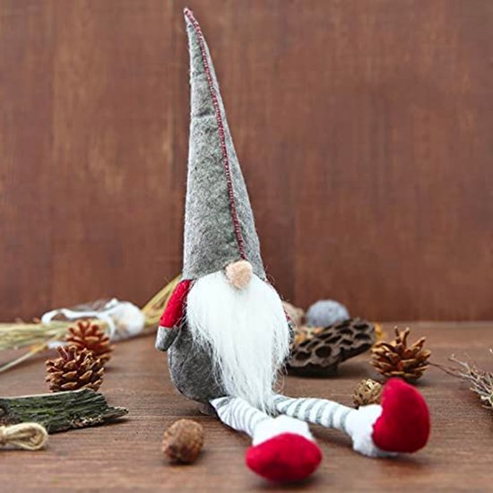 Un nain de Noël avec un bonnet pointu gris, une barbe blanche, des jambes rayées et des pieds rouges.