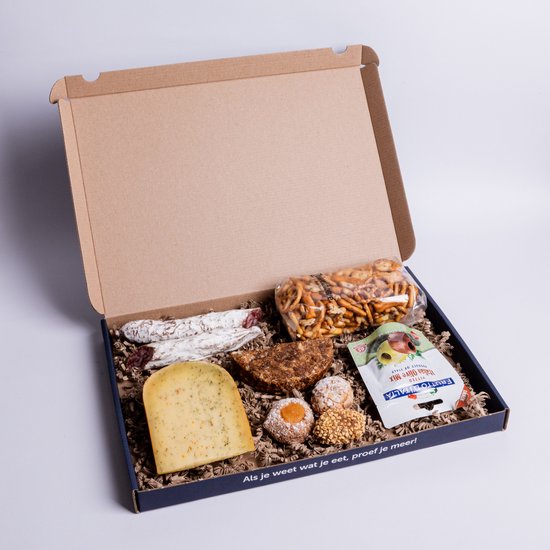 Gouden kaas, worstjes, koekjes, pretzels en tapenade in een doos.