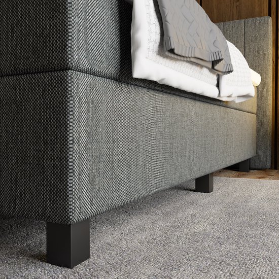 Grijze boxspring met antraciet gestoffeerd hoofdbord en vierkante zwarte pootjes.