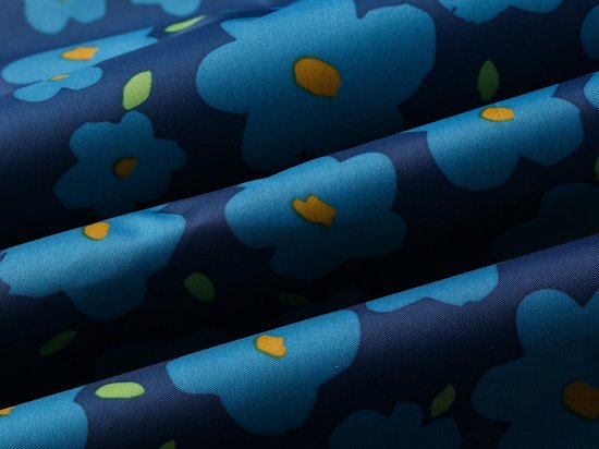 Gedetailleerde close-up van een donkerblauwe stof met een opvallend patroon van grote blauwe bloemen met gele spikkels en groene blaadjes.