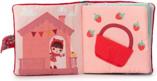 Open stoffen boekje met Roodkapje op een roze veranda en een mand met aardbeien.