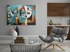 Peinture abstraite style Picasso avec deux visages, fond bleu, dans un salon avec fauteuil et table basse.