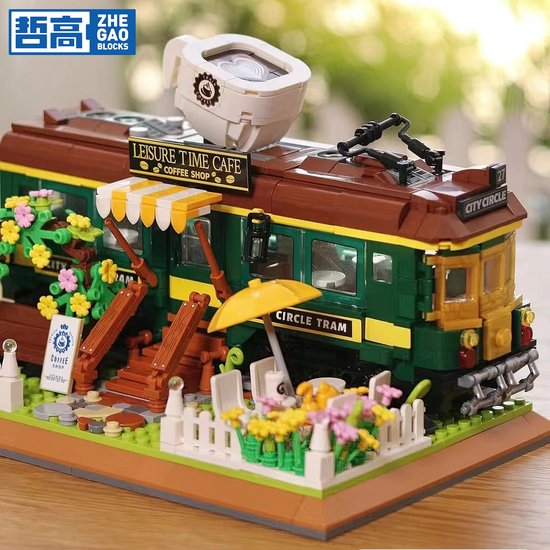 Blauwe en bruine tram, "Leisure Time Cafe" erop, met bloemen, tafels en parasol.