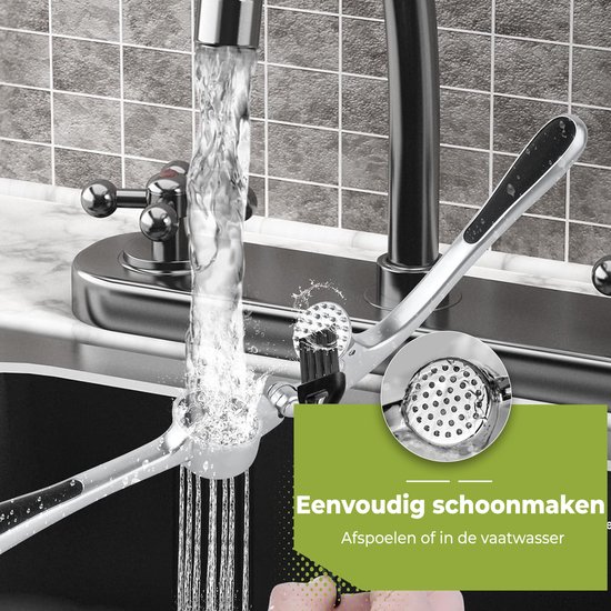 Zilverkleurige knoflookpers onder de kraan, schoongemaakt met een borsteltje.