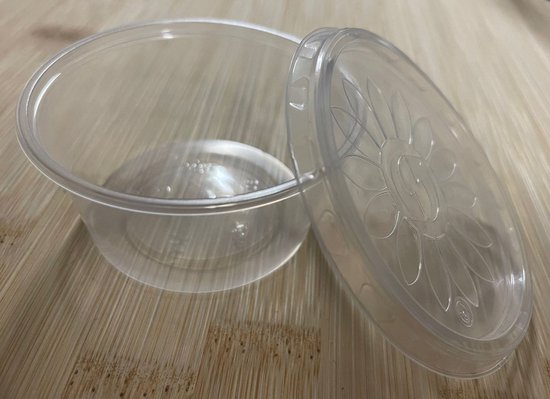 Transparant plastic bakje met deksel met bloemenmotief, deksel los.