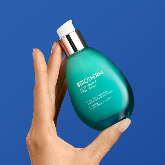 Hand houdt Biotherm Aquasource Deep Serum fles vast, teal-kleurig, heldere pompkop.
