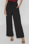 Zwarte wijde broek met trekkoord en steekzakken, gedragen met sandalen.