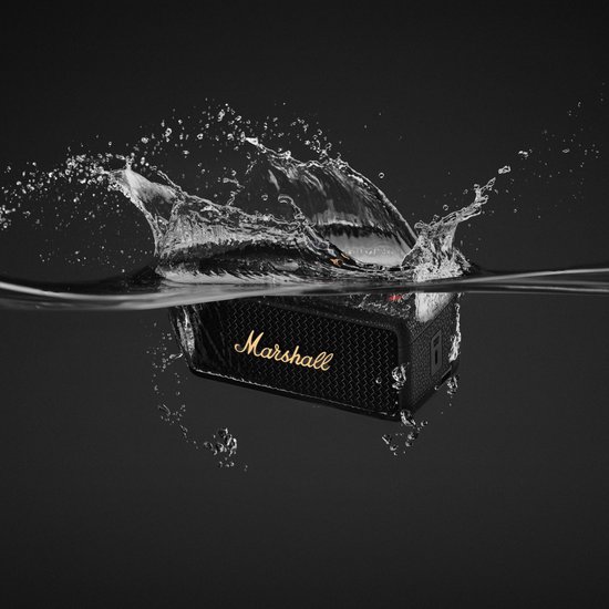 Zwarte Marshall-speaker met goudkleurig logo, half ondergedompeld in water met grote spatten.