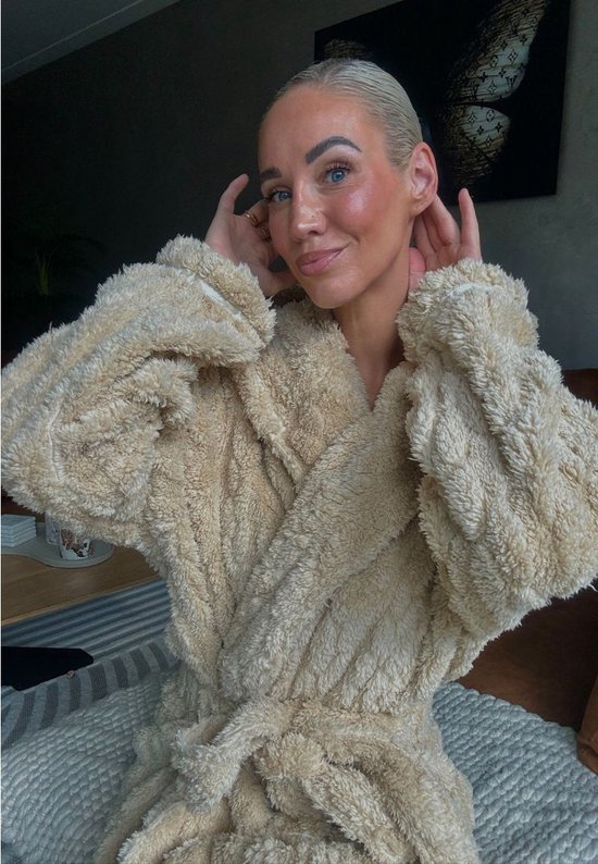 Beige badjas met capuchon van zacht fleece, close-up van een vrouw.