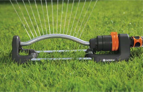 Zwenksproeier met zwarte basis, oranje connector en sproeiende waterstralen op gras.