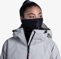Vrouw met paardenstaart draagt een zwarte nekwarmer en een lichtgrijze jas met capuchon.