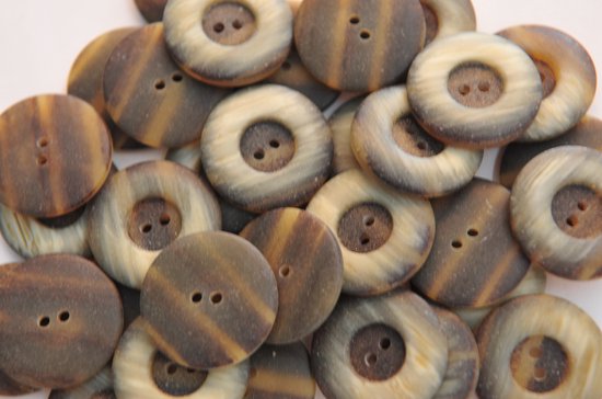 Beau bouton crème/marron 2 trous. Diamètre 25 mm. Sachet de 10 pièces.