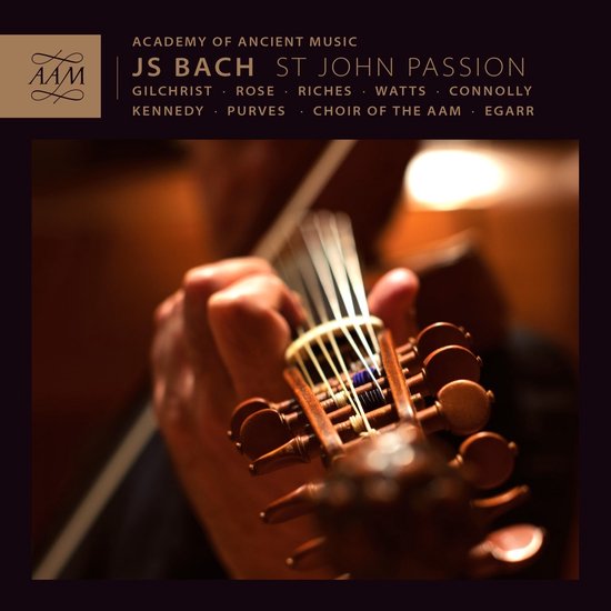 Close-up van een strijkersinstrument, met de hand van een muzikant die de snaren vasthoudt. Text AAM Records, JS Bach St John Passion.